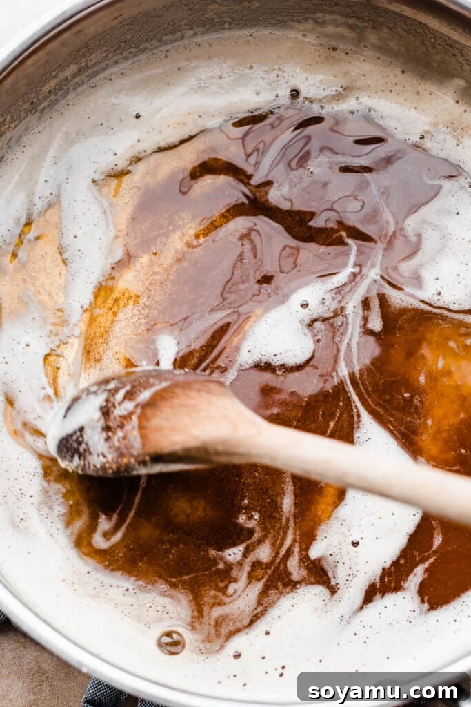 Nutty Brown Butter Thick Chewy Sugar Cookies 5 A pan of brown butter being stirred by a wooden spoon, showing the golden-brown color.