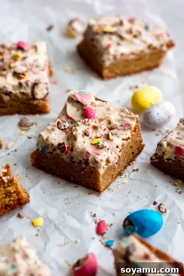Irresistible Easter Egg Blondies - Thick, Buttery, Caramel-y Bars with Robin's Egg Candy Frosting for a Perfect Spring Dessert Festive Easter egg blondies arranged on a baking sheet, showcasing their thick, buttery texture and colorful candy topping.