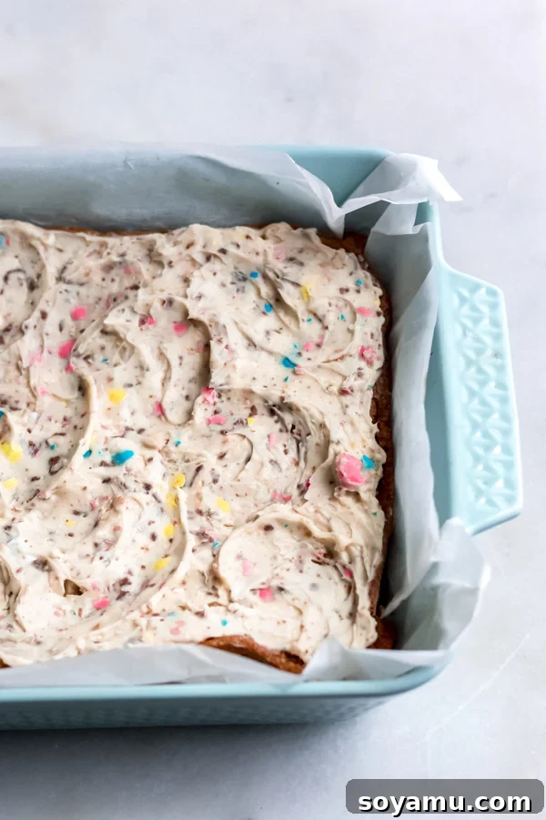 Frosted Easter Egg Blondies: A Symphony of Sweetness and Crunch Easter egg blondies spread with a generous layer of Robin Egg candy frosting, still in the baking pan.