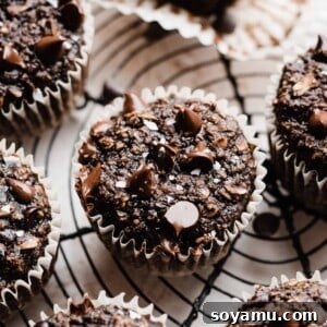 A basket of healthy banana chocolate oat muffins, fresh from the oven, cooling on a wire rack.