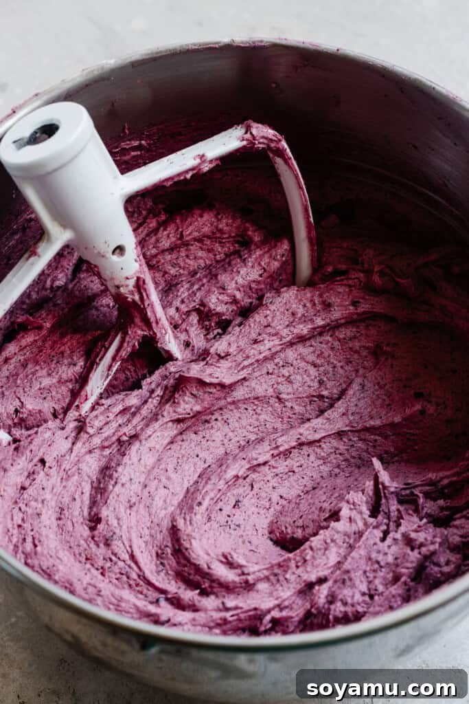 Blueberry Bliss Cake 14 A bowl of vibrant, smooth blueberry frosting, ready to adorn the cake layers.