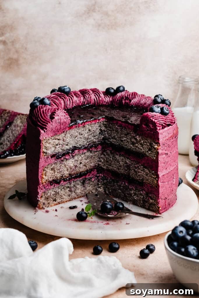 Blueberry Bliss Cake 18 A wide shot of a sliced blueberry cake on a elegant marble cake plate, with milk bottles blurred in the background, inviting a delicious tasting experience.