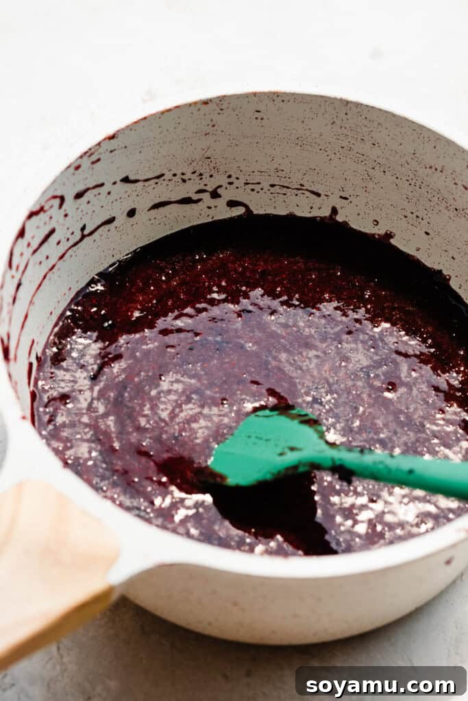 Blueberry Bliss Cake 6 Sieved blueberry liquid simmering in a saucepan, beginning the reduction process.