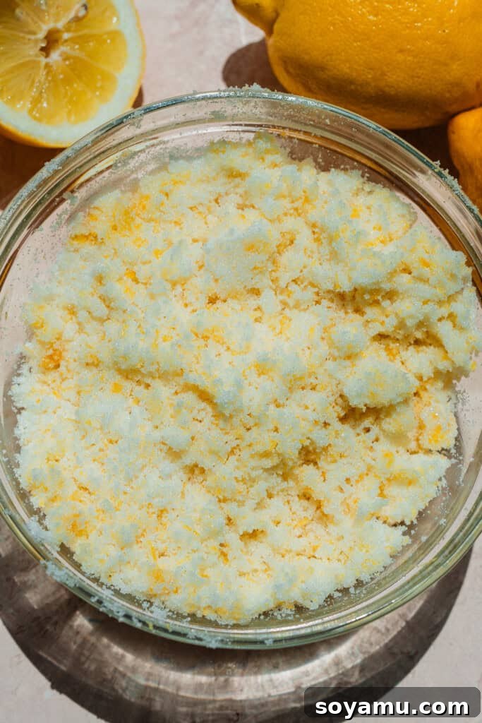Velvet Lemon Mascarpone Cake 4 Hands rubbing lemon zest into granulated sugar to create lemon zested sugar for the cake.
