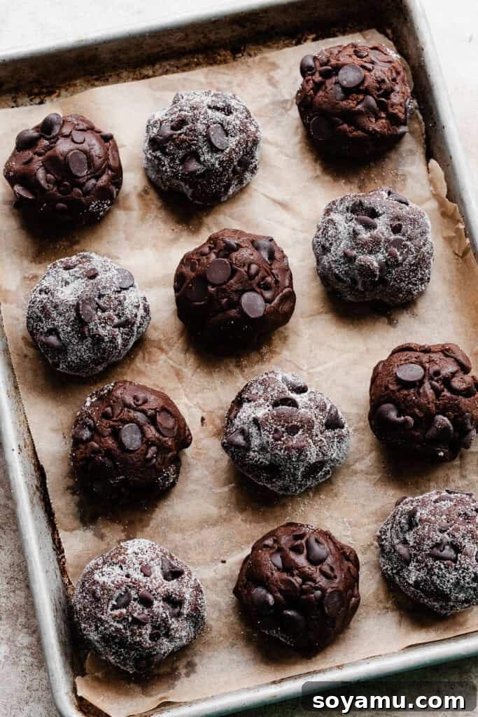 Decadent Double Chocolate Chip Cookies 5 A baking pan meticulously arranged with neatly scooped balls of double chocolate chip cookie dough, ready for chilling or baking.