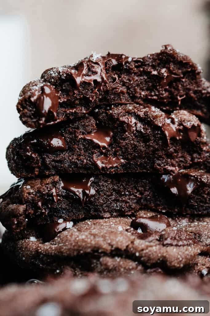 Decadent Double Chocolate Chip Cookies 8 A close-up shot of a stack of chocolate cookie halves, revealing their incredibly fudgy and moist insides, rich with melted chocolate.