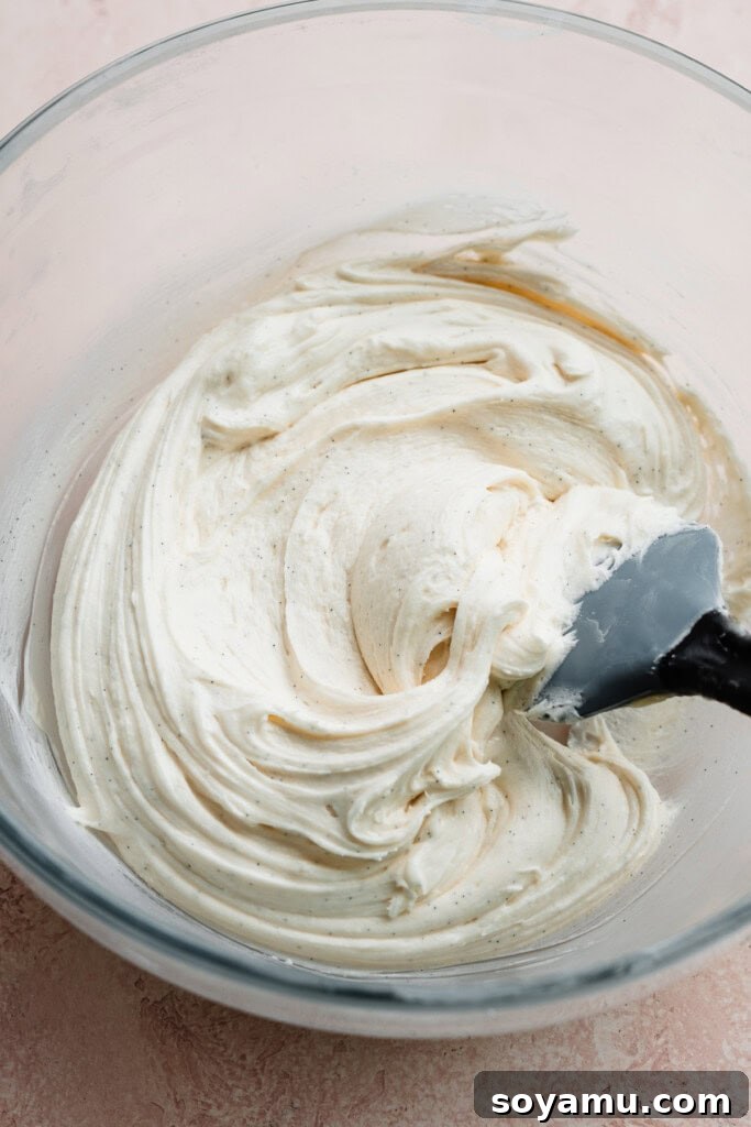 A close-up of a bowl filled with creamy, perfectly whipped vanilla frosting, smooth and ready for decorating.