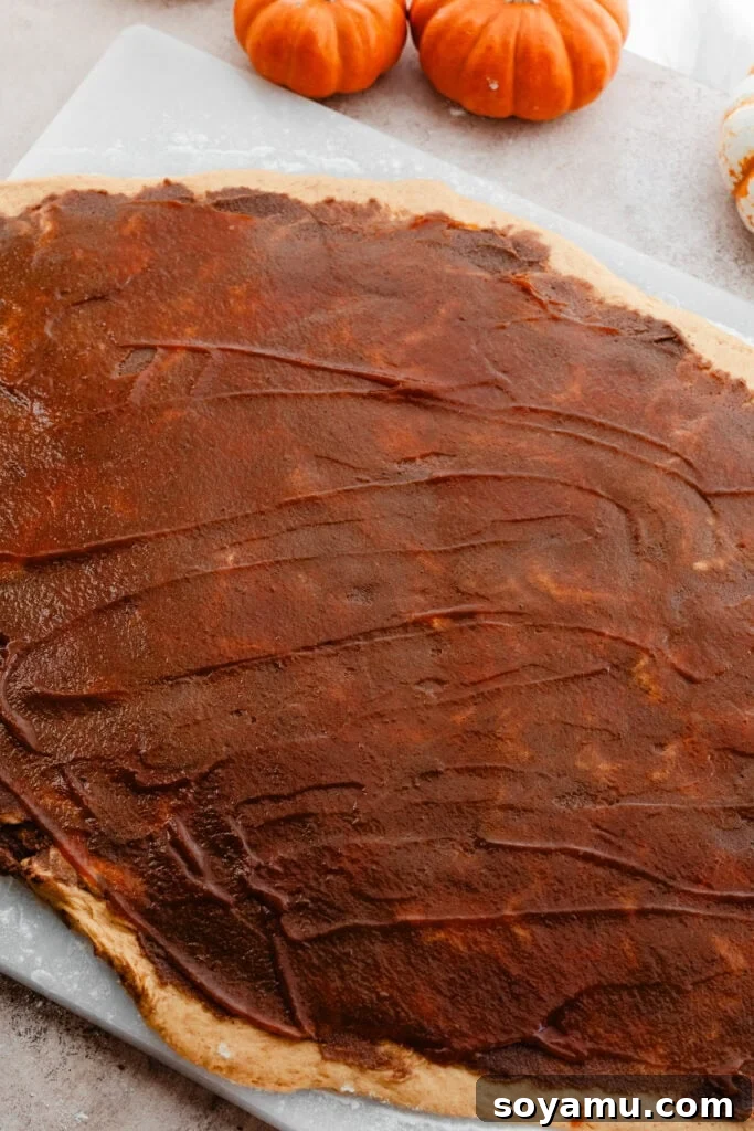 The dough rolled out and spread with both cinnamon filling and pumpkin butter.
