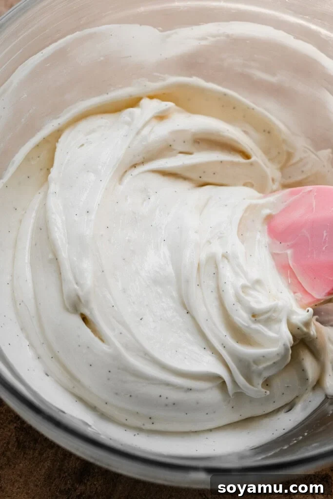 A bowl of creamy, cinnamon-spiced cream cheese frosting, ready to be spread.
