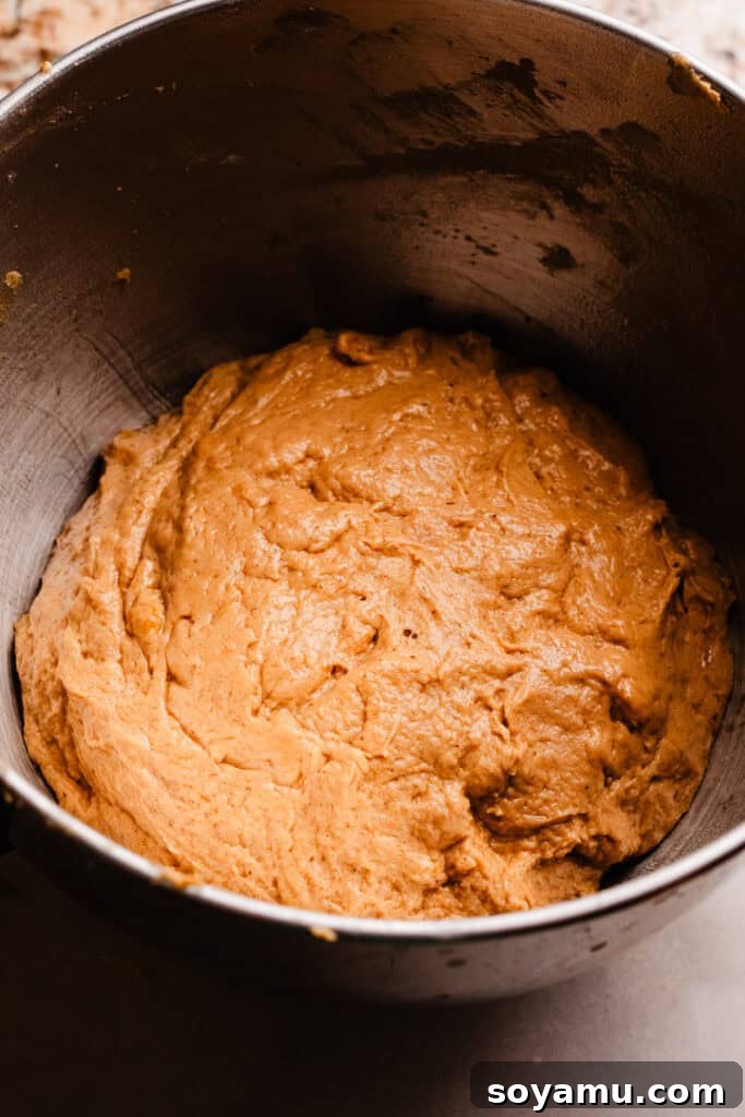 Pumpkin cinnamon roll dough in a bowl, before its first rise.