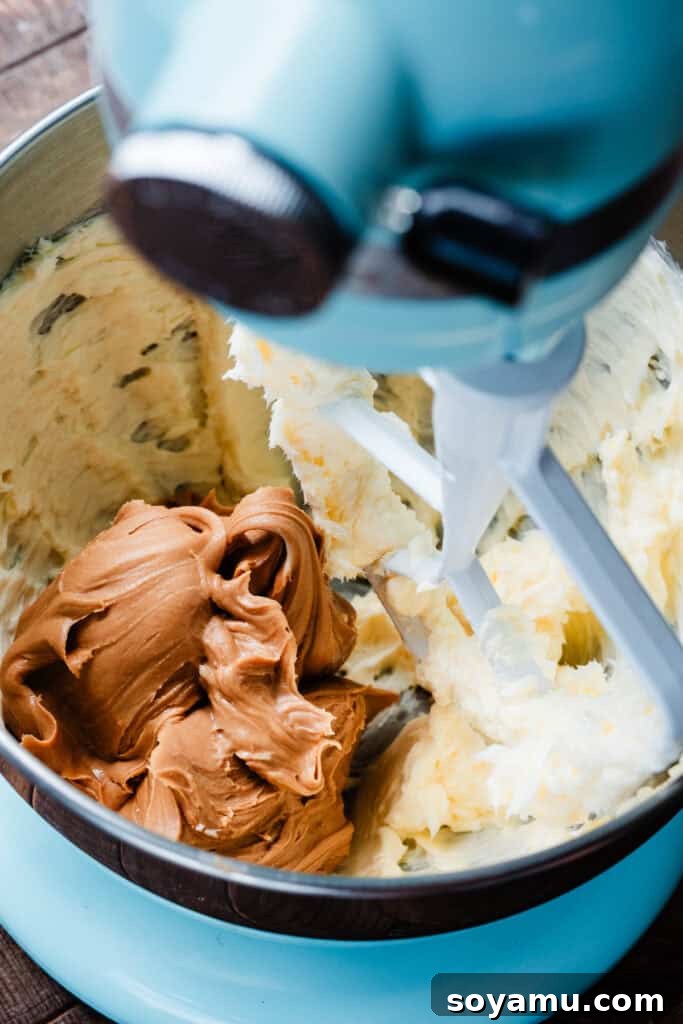 Decadent Peanut Butter Frosting Ready in 10 5 Creamy peanut butter added to the bowl containing the beaten butter, ready for mixing.