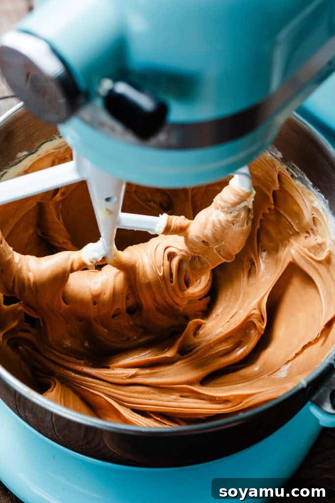 Decadent Peanut Butter Frosting Ready in 10 6 A silky smooth, light brown mixture of peanut butter fully combined with butter in a stand mixer bowl.