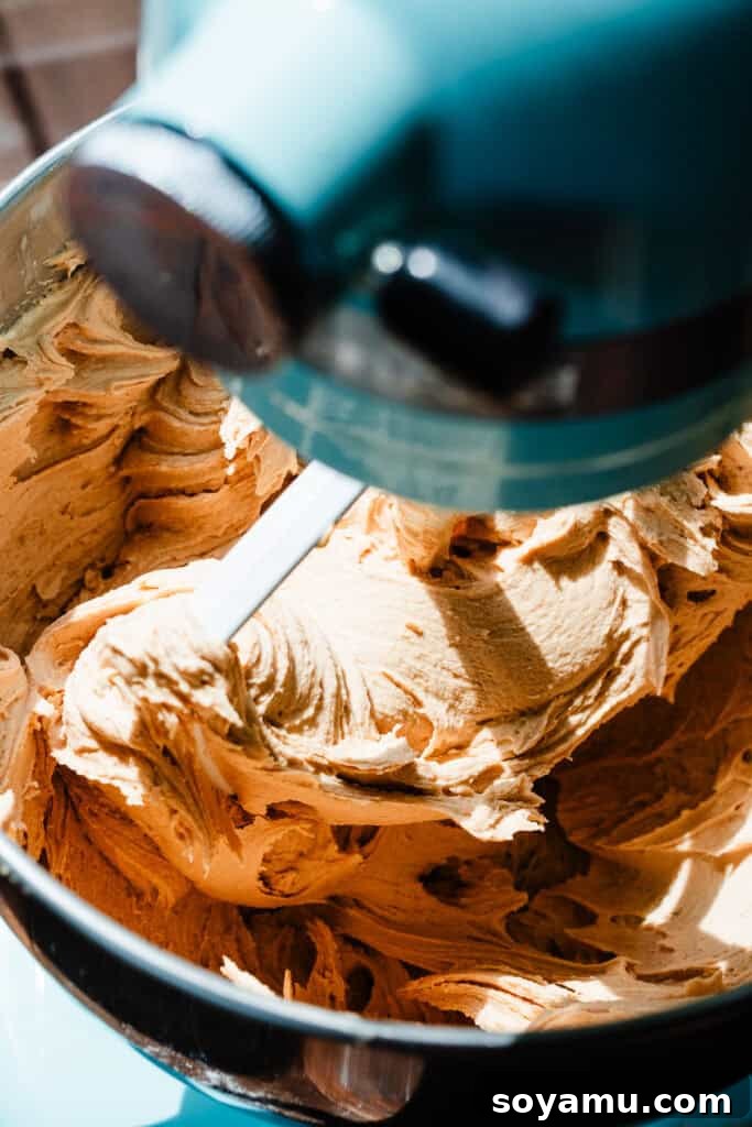Decadent Peanut Butter Frosting Ready in 10 8 A beautifully smooth and fluffy peanut butter frosting, perfectly whipped, resting in the bowl of a stand mixer.
