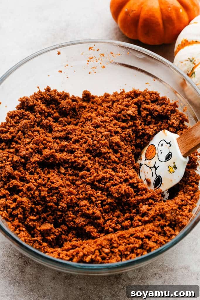Perfectly Simple Pumpkin Pie Bars 4 A bowl filled with the finely crushed Biscoff cookie crumbs mixed with melted butter, ready for the pan.