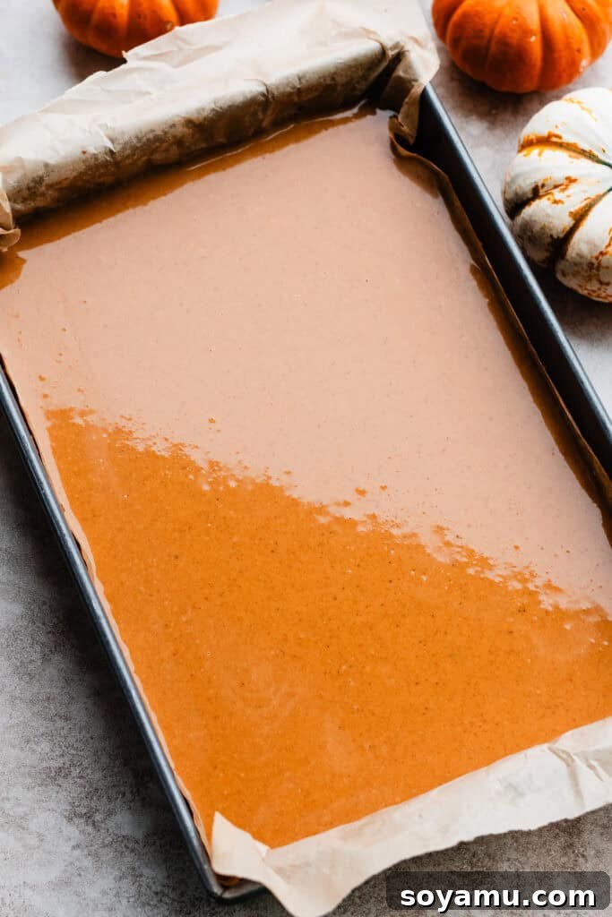 Perfectly Simple Pumpkin Pie Bars 7 The smooth pumpkin filling poured over the baked Biscoff crust, prepared for the oven.