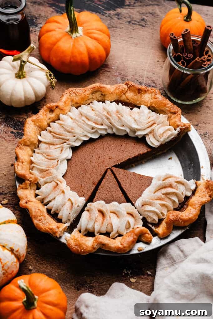 Autumn's Best Pumpkin Pie 11 A rustic and inviting scene: a whole Perfect Pumpkin Pie, sliced and topped with fresh whipped cream, resting on a warm wooden surface.