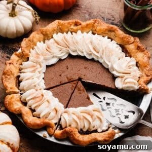 A classic pumpkin pie, perfectly baked with a golden crust, ready to be served. Ideal for holiday gatherings.