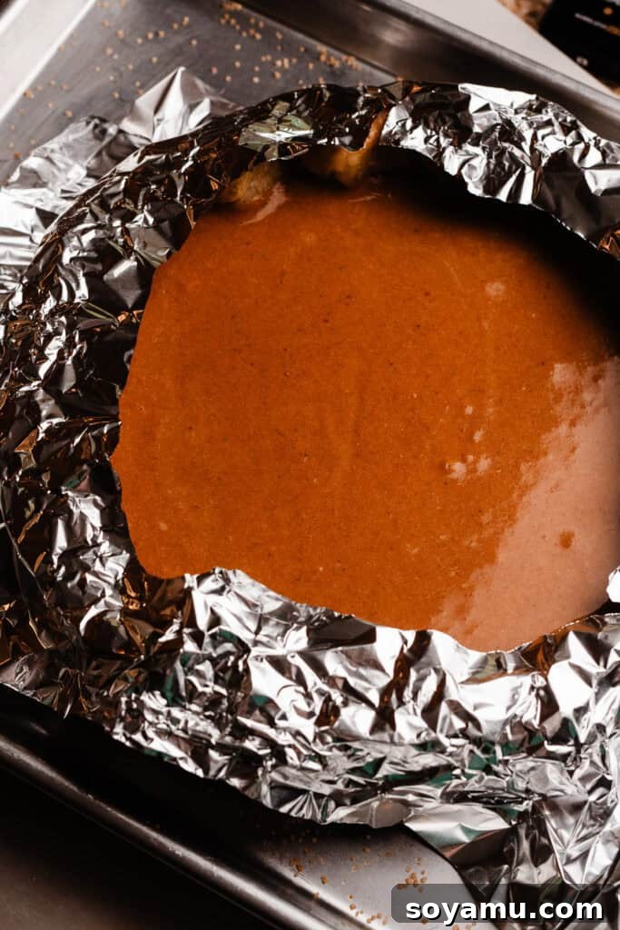 Autumn's Best Pumpkin Pie 8 The pumpkin pie, ready for baking, with a homemade foil pie shield protecting the crust edges from burning.