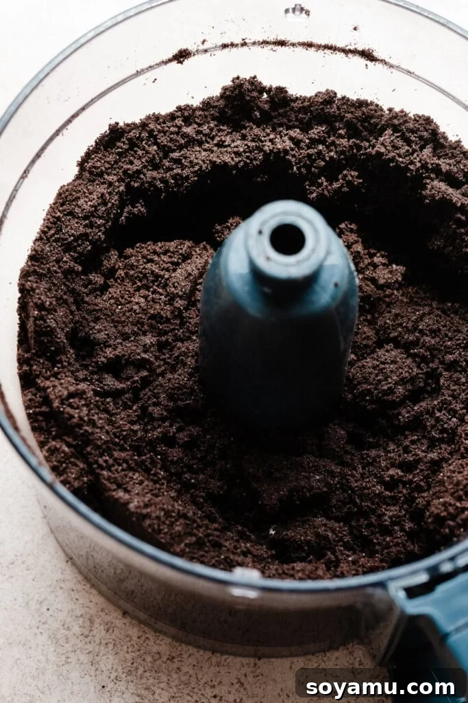 Simple Two Ingredient Oreo Dessert Crust 4 Finely crushed Oreo cookies in a food processor, forming the base for an easy dessert crust with a uniform, dark crumb texture.