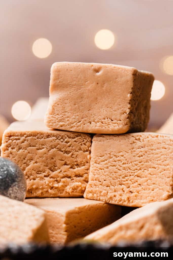 A close-up view of neatly stacked pieces of smooth, creamy peanut butter fudge, showcasing their irresistible texture.