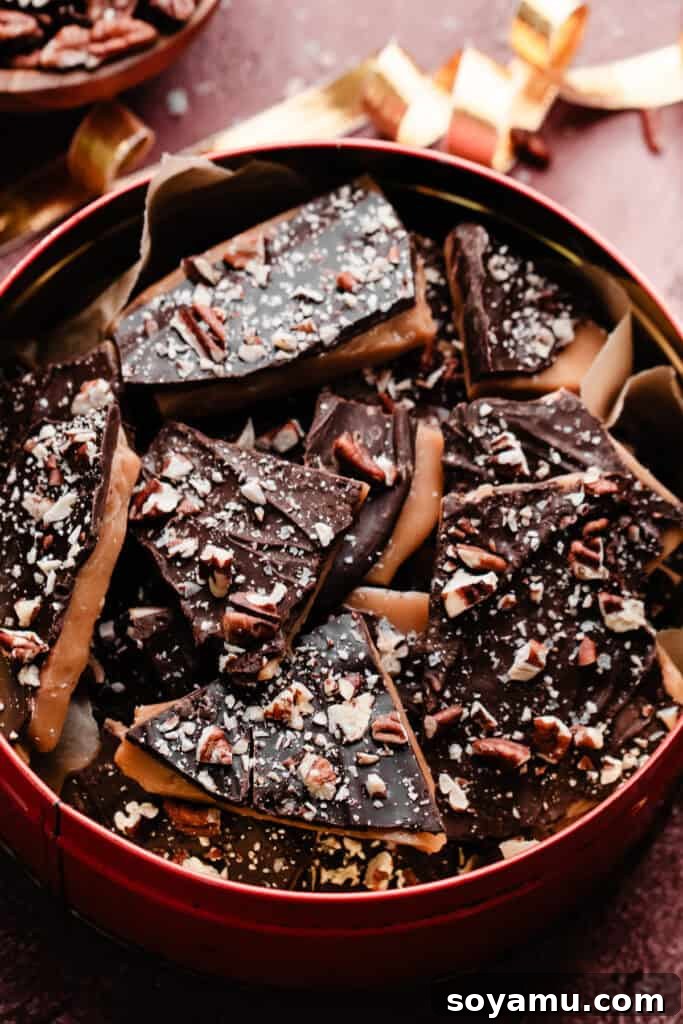 Numerous pieces of homemade toffee, artfully arranged inside a charming vintage Christmas tin, suggesting a perfect holiday gift or festive treat.