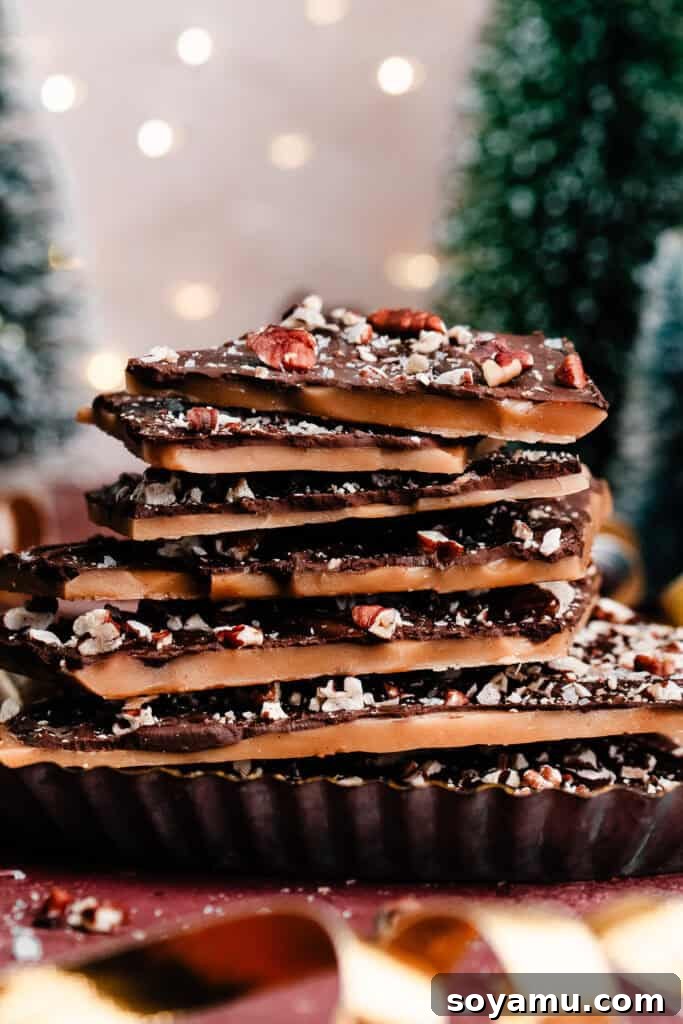 A stack of golden homemade toffee pieces, each perfectly coated with chocolate and toasted pecans, inviting a delicious bite.