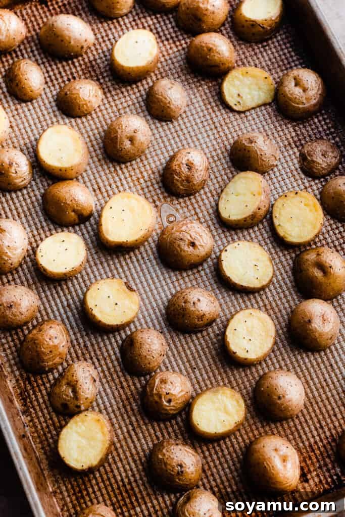 Sheet Pan Caramelized Maple Salmon with Crispy Potatoes 4 The partially roasted potatoes on a baking sheet.
