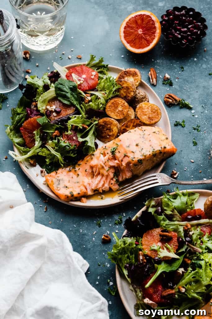 Sheet Pan Caramelized Maple Salmon with Crispy Potatoes 9 Two plates with maple glazed salmon, salad, and roast potatoes.