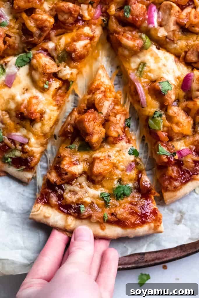 Our Favorite Barbecue Chicken Pizza - Pizza night just got even more delicious! An easy homemade crust is the base for this pizza made with chicken, barbecue sauce, mozzarella and colby jack cheese, green pepper, and red onion. This is what every weekend (and weeknight!) calls for! #barbecuechicken #chicken #pizza #barbecuechickenpizza #bbq #bbqchicken #homemadepizza #weeknightdinner #easydinner | bluebowlreicpes.com Delicious slices of homemade barbecue chicken pizza, ready to serve.
