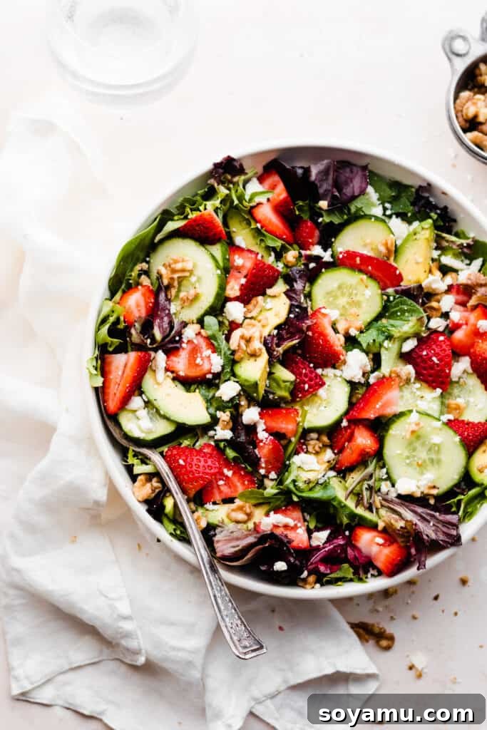 Vibrant Strawberry Cucumber Salad with Goat Cheese and Toasted Walnuts 5 The tossed salad in a serving bowl.