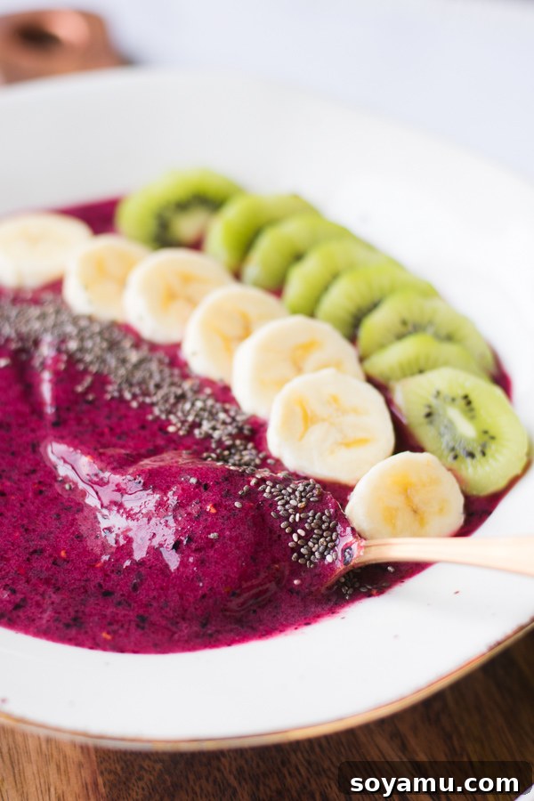 Overhead shot of a berry and banana smoothie bowl with various toppings