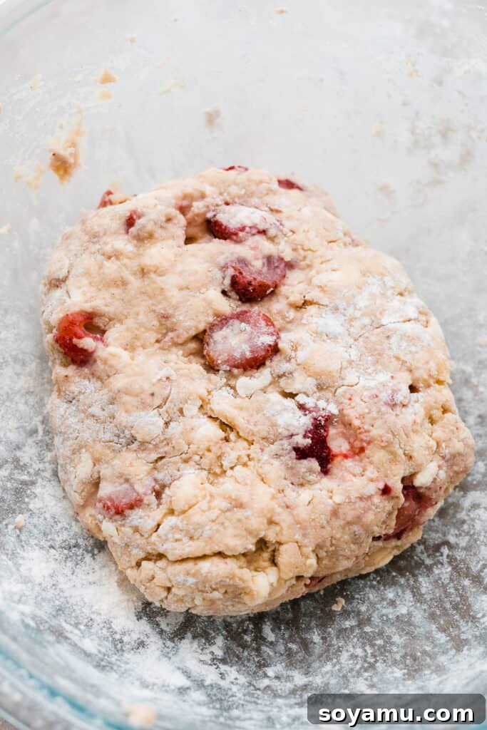 Strawberry Cream Scones 2 A bowl filled with the strawberry scone dough, showing the vibrant red of the berries and specks of white chocolate, ready to be formed.