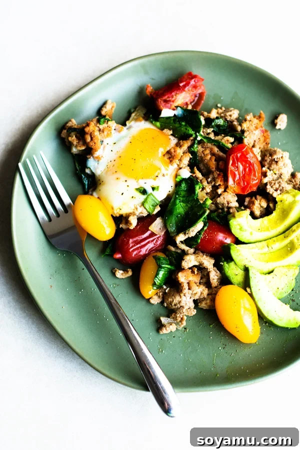 Plated Healthy Taco Skillet showing a perfectly runny egg yolk, garnished with avocado and green onions