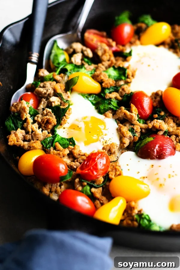 Close-up of a spoon scooping into the Healthy Taco Skillet, revealing the irresistible runny yolk texture
