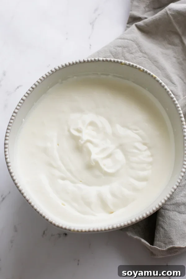 Effortless Vanilla Bean Ice Cream with Sweet Roasted Rhubarb 6 Close-up of perfectly whipped heavy cream, showcasing stiff peaks ready for no-churn ice cream preparation