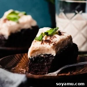Two slices of baileys chocolate cake topped with baileys cream cheese frosting on cake plates.