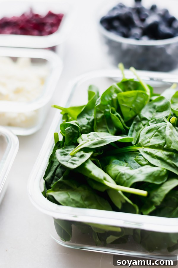 10 Easy Ways to Improve Your Food Photography - 10 Quick + easy tips to take your food photography to the next level! #foodphotography #foodphotos #bloggers #bloggingresources #blogresources #bloggerresources #photographyresources #photographytips | bluebowlrecipes.com Fresh green spinach leaves in a container, with a shallow depth of field showcasing sharp focus on the leaves and a blurred background, demonstrating the use of aperture.