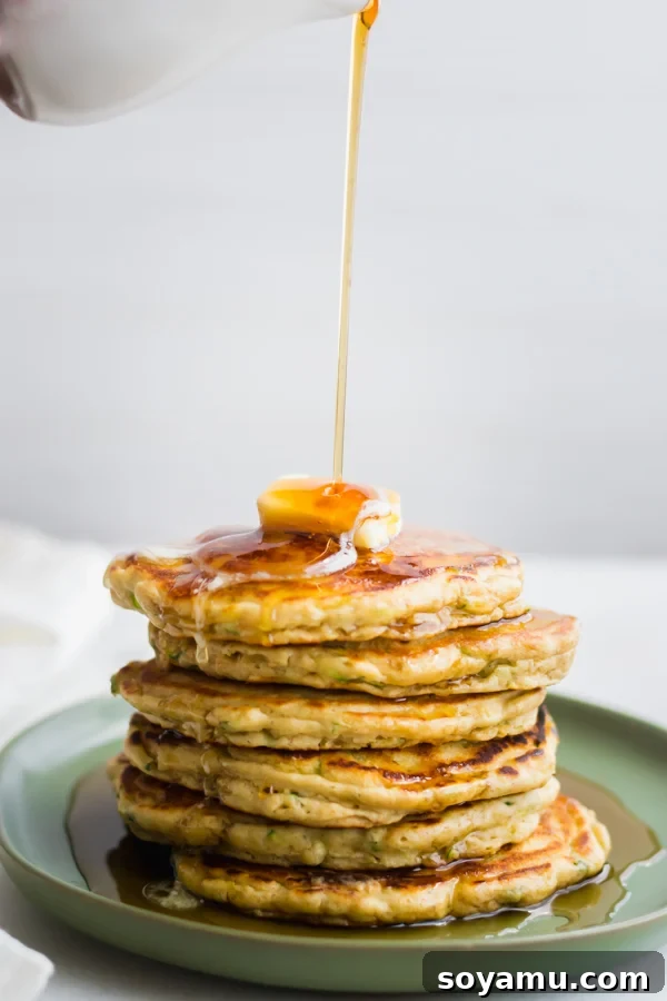 10 Easy Ways to Improve Your Food Photography - 10 Quick + easy tips to take your food photography to the next level! #foodphotography #foodphotos #bloggers #bloggingresources #blogresources #bloggerresources #photographyresources #photographytips | bluebowlrecipes.com Delicious pancakes with syrup being poured over them, served on a matte plate with a matte pitcher, showcasing how non-reflective props enhance food photography.