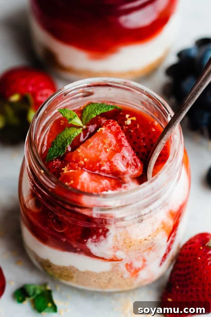 No-Bake Mini Cheesecake Jars 7 A close-up of a strawberry compote topped mini cheesecake.