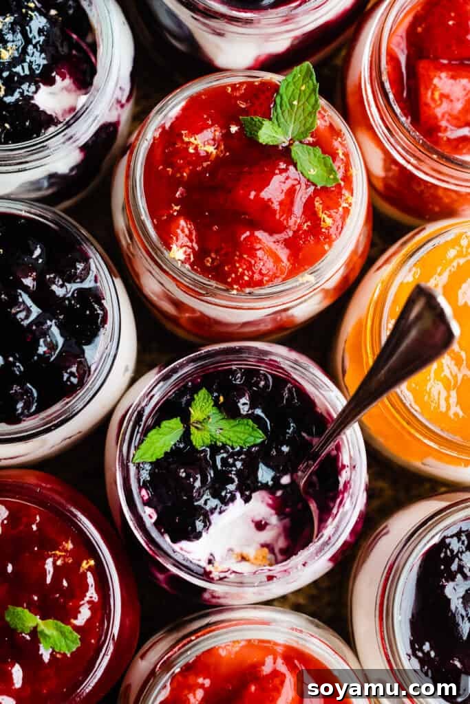 No-Bake Mini Cheesecake Jars 10 A bird's eye view of many mini cheesecake jars with different fruit fillings.