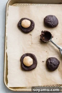 Decadent Chocolate Cookies with Gooey Caramel Centers 3 Cookie dough balls with caramel filling before baking.