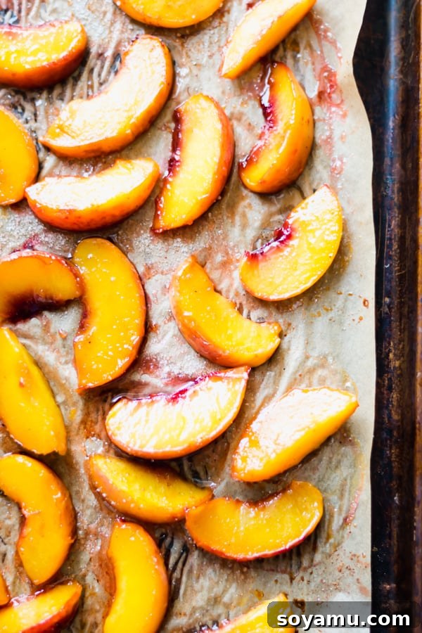 Peach Crisp Yogurt Parfaits 6 Roasted peach slices beautifully laid out on a baking tray, showcasing their tender and caramelized texture.