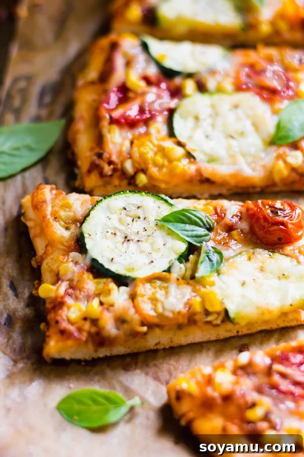 Slices of Roasted Tomato, Corn, and Zucchini Flatbread Pizza served on a platter, ready to eat.