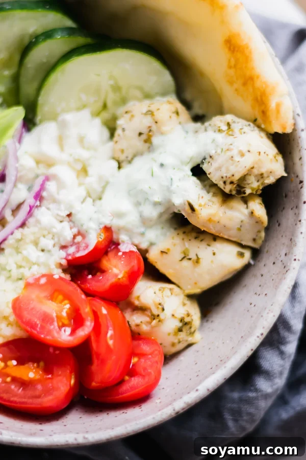 Savory Chicken Gyro Bowls with Artisan Tzatziki 5 A complete chicken gyro bowl featuring lemon-herb chicken, couscous, a vibrant mix of fresh greens, tomatoes, feta, red onions, and cucumber, drizzled with tzatziki.