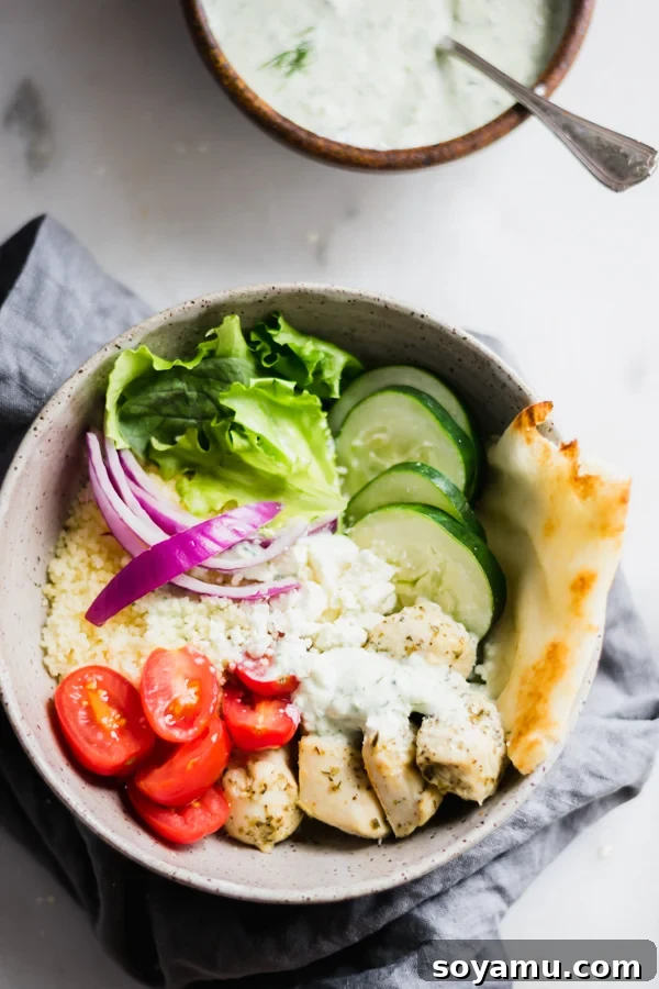 Savory Chicken Gyro Bowls with Artisan Tzatziki 8 Two bowls, one with a fully assembled chicken gyro bowl, and another smaller bowl holding homemade tzatziki sauce, indicating a perfect pairing.