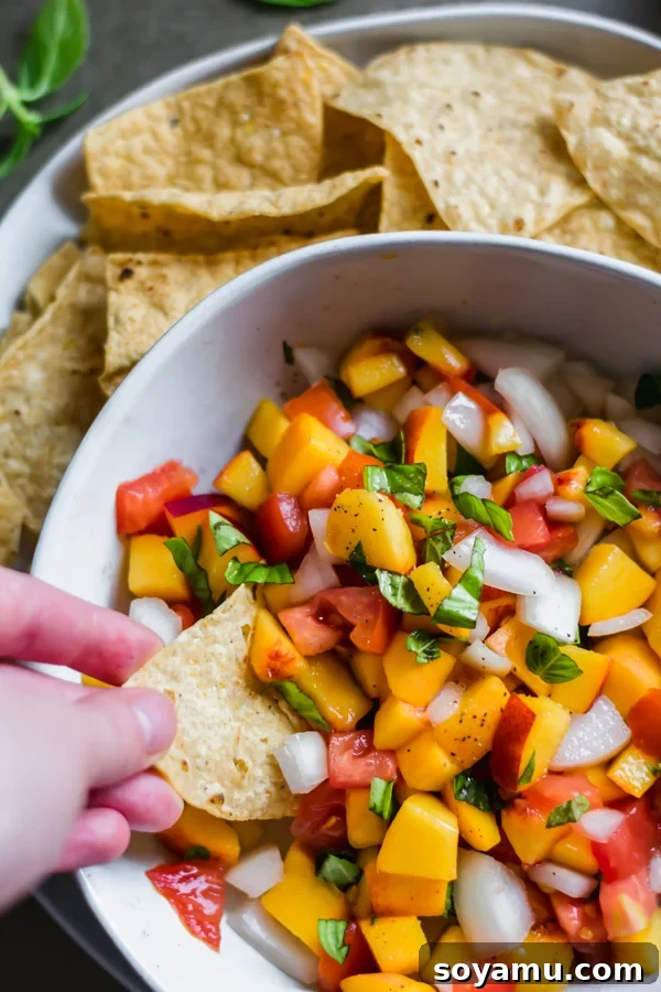 Vibrant peach salsa in a bowl with tortilla chips, ready to be served.