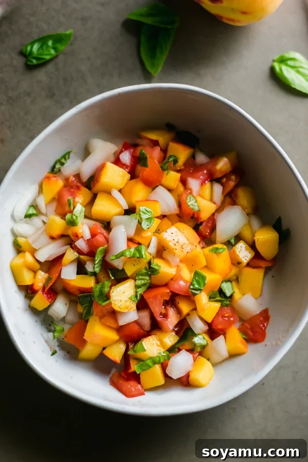 A close-up of fresh peach salsa in a white bowl.