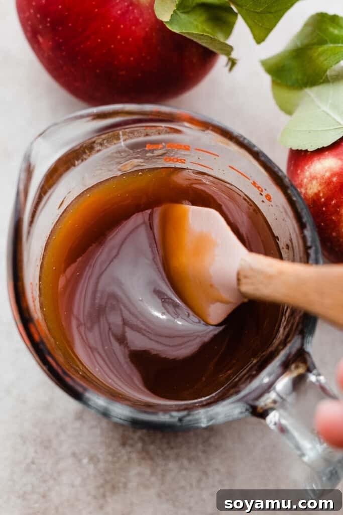 Ultimate Baked Apple Cider Donuts 5 A measuring cup full of syrupy reduced apple cider.