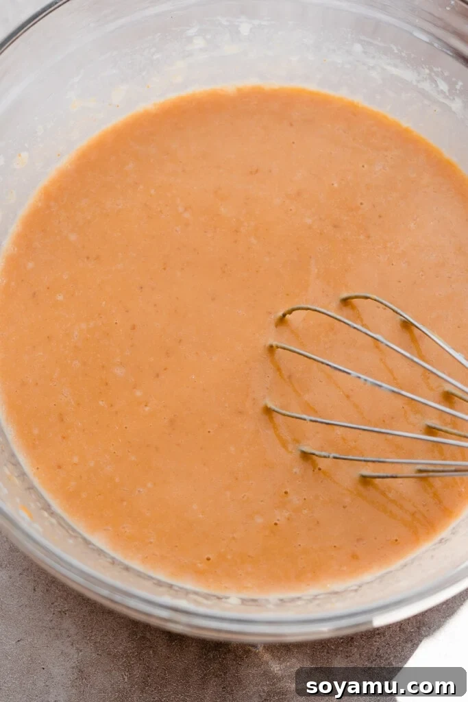 Pillowy Pumpkin Spice Pancakes 4 A bowl containing the smooth, orange wet ingredient mixture for pumpkin pancakes.