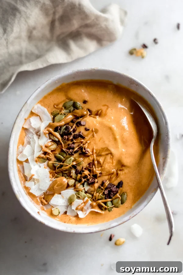 Fall Glow Smoothie Bowl - A delicious, creamy smoothie made with real food ingredients and lots of fall flavor. All you need for this filling breakfast is 6 ingredients and 10 minutes! #bluebowlrecipes #fall #smoothie #smoothiebowl #sweetpotato #dairyfree #vegan #glutenfree #breakfast #healthybreakfast | bluebowlrecipes.com Fall glow smoothie bowl, beautifully garnished with coconut chips, cacao nibs, and pepitas.